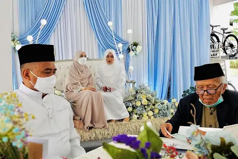 SUASANA SANTAI: Encik Azman (kiri) memilih mengadakan majlis walimahnya di kolong blok 241 Jurong East semasa berkahwin dengan isterinya, Cik Nurul Aini, Mei lalu. - Foto ihsan AZMAN SULAIMAN