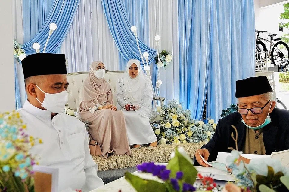 SUASANA SANTAI: Encik Azman (kiri) memilih mengadakan majlis walimahnya di kolong blok 241 Jurong East semasa berkahwin dengan isterinya, Cik Nurul Aini, Mei lalu. - Foto ihsan AZMAN SULAIMAN