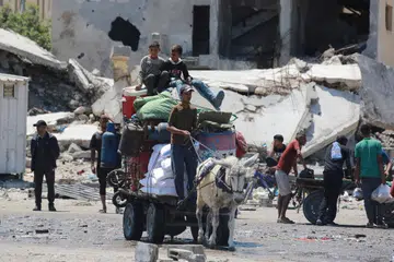 Para penduduk Palestin melarikan diri dan membawa bersama barangan keperluan dengan menggunakan kereta sorong yang ditarik keldai ketika perang membahang di Rafah, selatan Gaza.