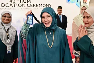 Tengku Ampuan Pahang, Tunku Azizah Aminah Maimunah Iskandariah (tengah), yang kembali bergelar mahasiswi pada usia 64 tahun, menunjukkan kad pelajar Universiti Islam Antarabangsa Malaysia (UIAM).