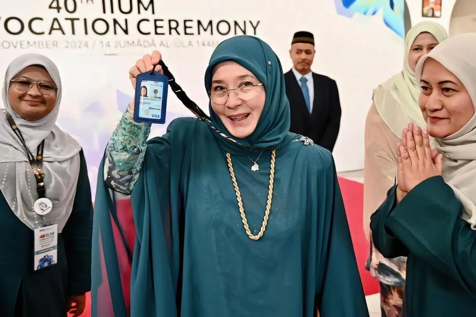 Tengku Ampuan Pahang, Tunku Azizah Aminah Maimunah Iskandariah (tengah), yang kembali bergelar mahasiswi pada usia 64 tahun, menunjukkan kad pelajar Universiti Islam Antarabangsa Malaysia (UIAM).