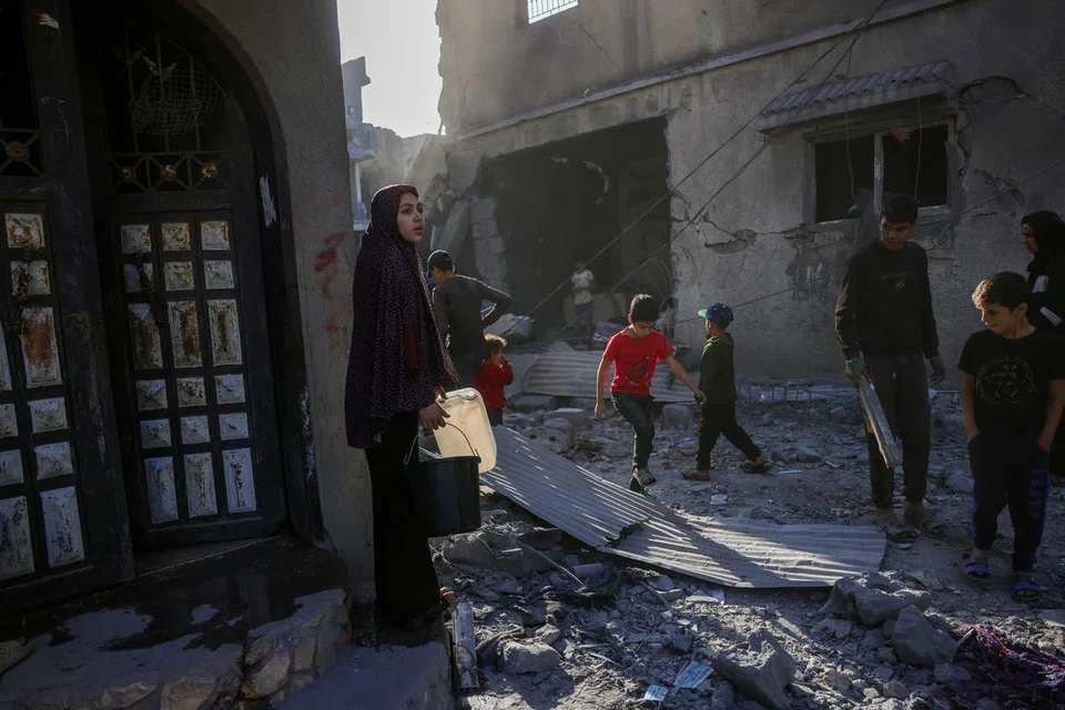 Penduduk Gaza memeriksa tapak serangan Israel di Jabalia di tengah Jaluran Gaza, pada 30 Mei, di tengah-tengah perang antara Israel dengan kumpulan militan Hamas.
