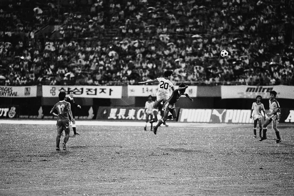 Penyerang Singapura, Razali Rashid (jersi nombor 20), melompat tinggi untuk menanduk bola menentang pertahanan Indonesia, A Sunardi. Ia merupakan pertembungan antara Singapura dengan Indonesia di perlawanan pertama Piala Merlion di Stadium Nasional pada 3 Disember 1983. Razali menjaringkan dua gol dalam kemenangan 5-0.