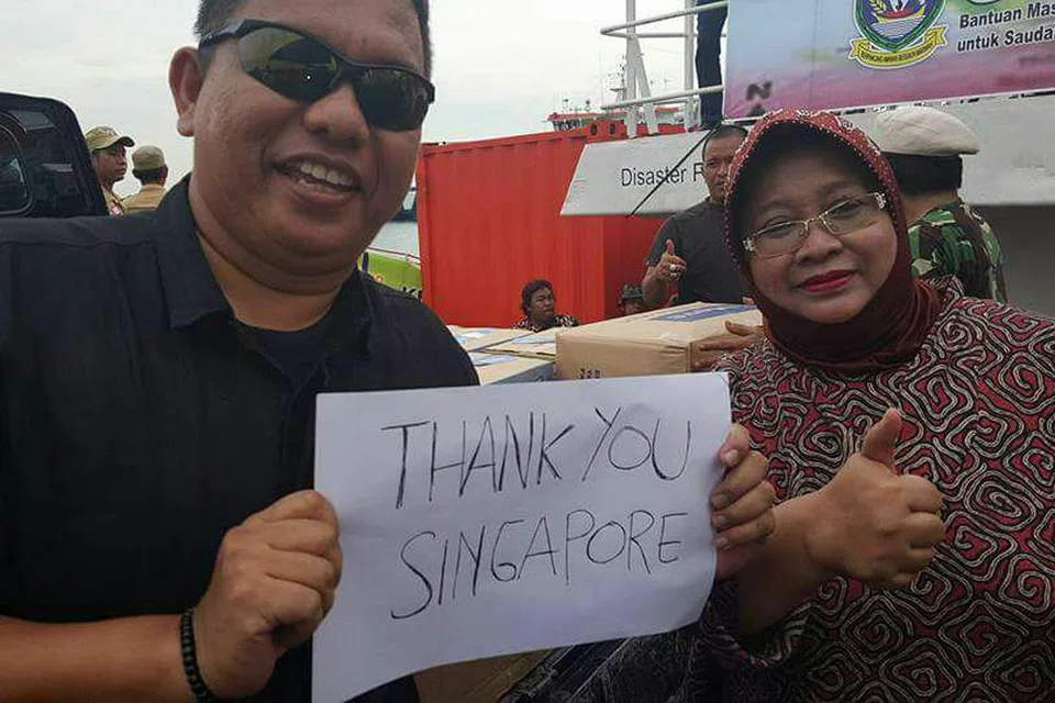 BERSYUKUR ATAS BANTUAN: Cik Noor Lizah Nurdin bergambar bersama Wali Kota Tanjung Pinang, Bapak Doli Boniara, yang memegang kertas dengan tulisan "Terima Kasih Singapura" atas sumbangan barangan yang amat memberangsangkan bagi mangsa gempa di Aceh.- Foto SITI NURANI SALIM 