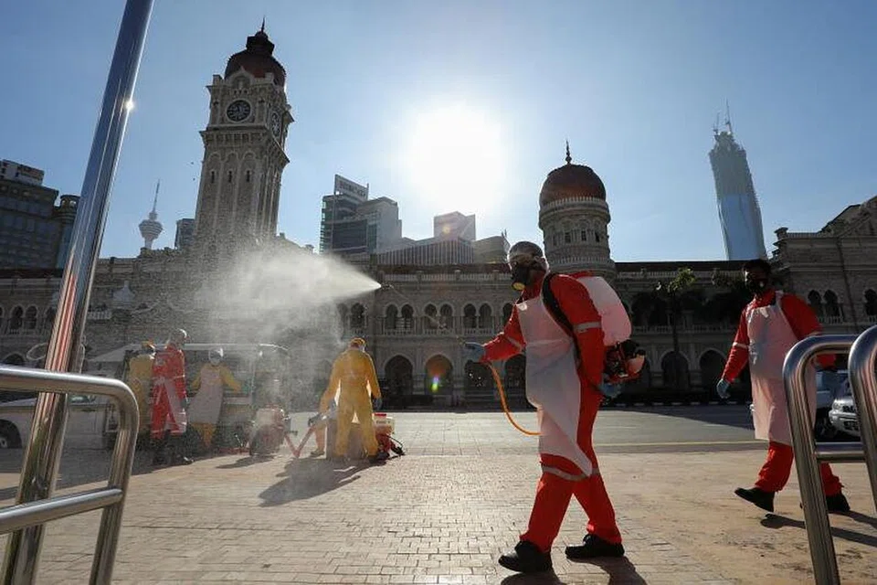 Seorang pekerja sedang menyah jangkit kawasan di Dataran Merdeka dalam satu operasi di tengah-tengah kes jangkitan yang terus meningkat di Malaysia. 
