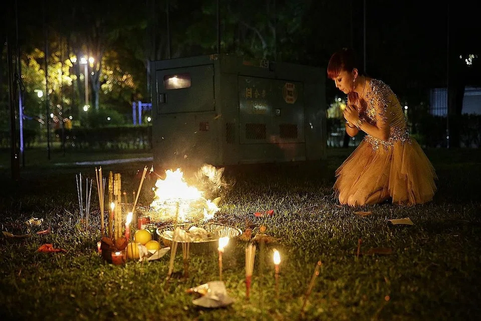 KEPERCAYAAN: Penyanyi 'getai', Yuan Jin membakar colok sebelum beraksi di pentas di tanah lapang Yung An Road Jumaat lalu sempena Pesta Bulan Hantu yang jatuh pada bulan ketujuh kalendar Cina. Ia bermula secara rasmi pada Khamis lalu. - Foto BH oleh KEVIN LIM