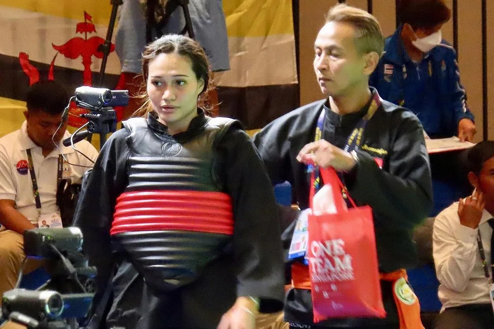 WAJAH KECEWA: Nurul Suhaila Saiful, yang terpaksa berpuas hati dengan pingat gangsa, diberi kata-kata perangsang oleh jurulatih nasional menyusuli kekalahannya kepada pesilat Vietnam, Quang Thi Thu Nghia. - Foto BH oleh ZULAIQAH ABDUL RAHIM