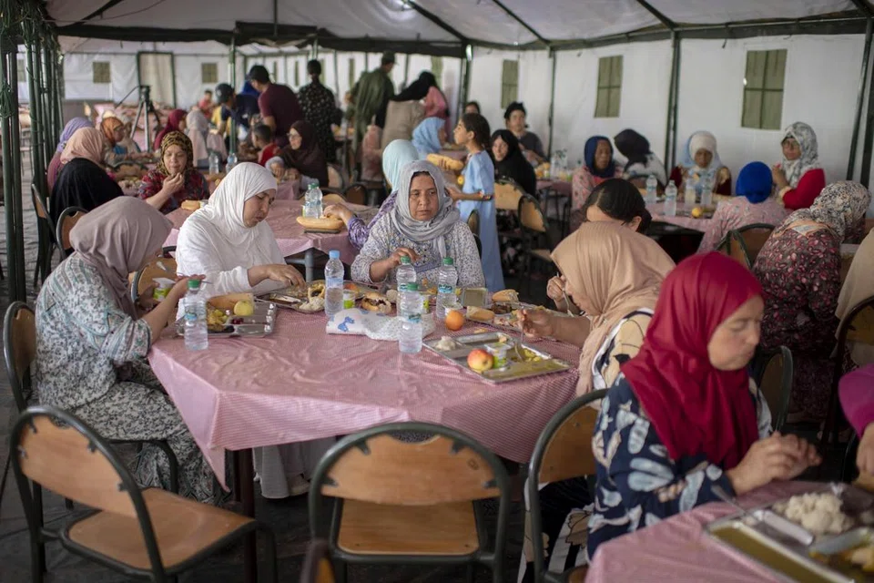BANTUAN DIBERI: Para penduduk yang terjejas oleh gempa bumi diberikan makanan yang diedarkan oleh Angkatan Bersenjata Diraja Maghribi di Amizmiz, selatan Marrakesh, Maghribi, pada 17 September 2023.