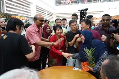 BERAMAH MESRA DENGAN PENDUDUK: Encik Tharman Shanmugaratnam dan isterinya, Cik Jane Ittogi bertemu dan berjabat tangan bersama penduduk di Pusat Penjaja Taman Jurong pada pagi Selasa.