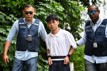 Warga China Wu Jinxing (tengah), dibawa ke kawasan rumah banglo di Holland Road pada 2 Ogos bagi menjejaki tempat simpan barang curi. 