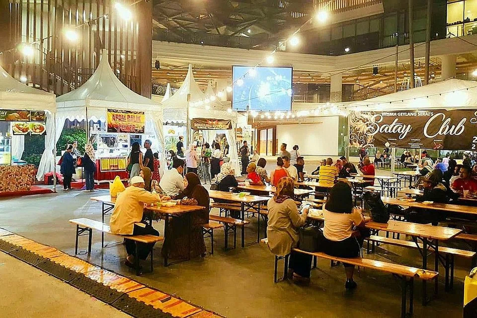 KEMBALIKAN NOSTALGIA: Bagi pengunjung yang menghadiri pesta Wisma Geylang Serai - Satay Club, mereka berkesempatan membeli pelbagai jenis hidangan sate yang dijual dan menikmatinya di bangku-bangku panjang yang disediakan. - Foto WGS