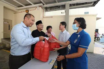 PERPADUAN DALAM KRISIS: Antara inisiatif yang diambil termasuk tajaan bersama Restoran Ayza dan Kumpulan Keyakinan Antara Kaum dan Agama (IRCC) Taman Jurong yang mengagihkan kotak-kotak makanan dan nota perghargaan kepada kakitangan di Poliklinik Jurong sebagai tanda sokongan dan penghargaan mereka kepada pekerja perubatan barisan hadapan (gambar atas) serta usaha kakitangan Free Food For All yang menghulurkan makanan berkhasiat kepada warga memerlukan menjaga kesihatan mereka. - Foto-Foto fail