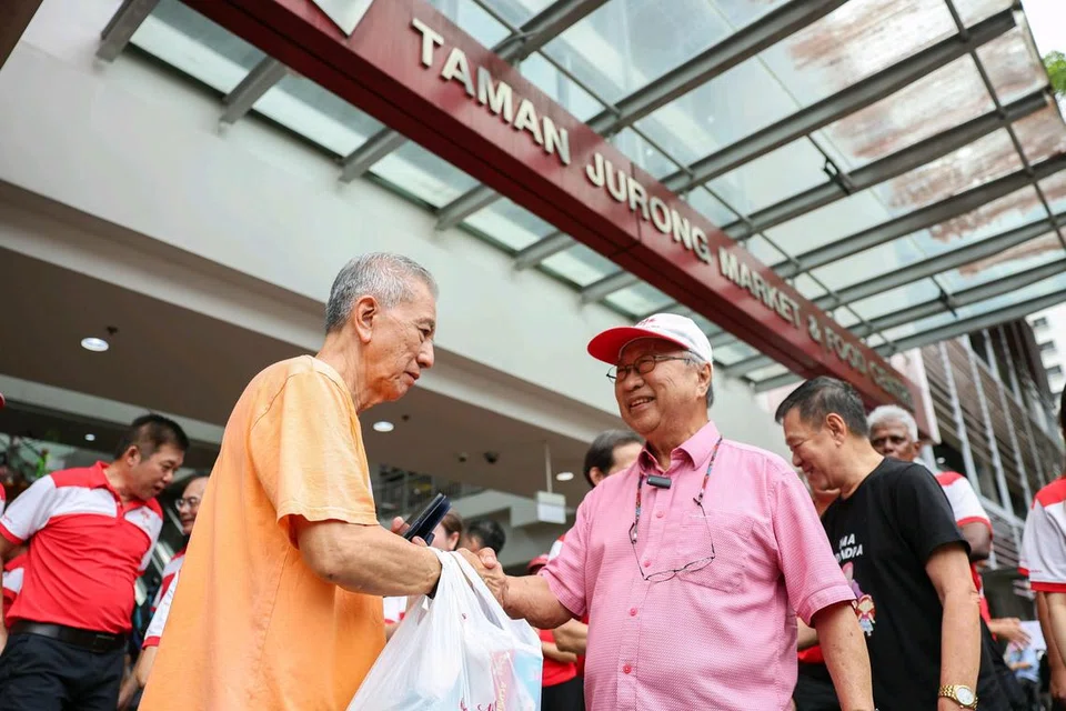 Pengerusi Parti Kemajuan Singapura (PSP), Encik Tan Cheng Bock (bertopi), bertemu penduduk di Taman Jurong dalam sesi bertemu penduduk parti itu di Pusat Makanan dan Pasar Taman Jurong baru-baru ini.