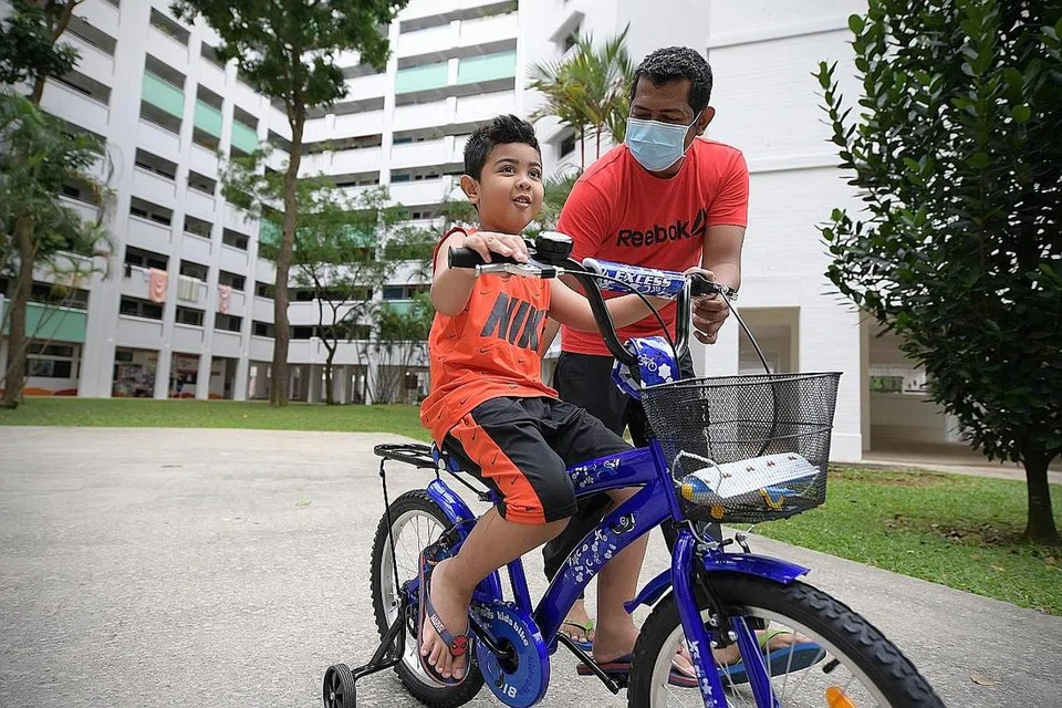 BELAJAR KAYUH BASIKAL: Encik Zul Bakri Abas mengajar anak sulungnya, Muhammad Syukri Naufal, lima setengah tahun, mengayuh basikal di sekitar estet perumahan mereka di Woodlands sejak tiga bulan lalu. - Foto-foto BH oleh NG SOR LUAN