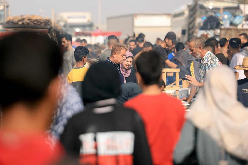 SERBA-SERBI KEKURANGAN: Para penduduk Palestin yang melarikan diri daripada utara ke selatan Gaza akibat pengeboman berterusan Israel, membeli makanan di sebuah kedai di Khan Yunis, di selatan Jaluran Gaza.