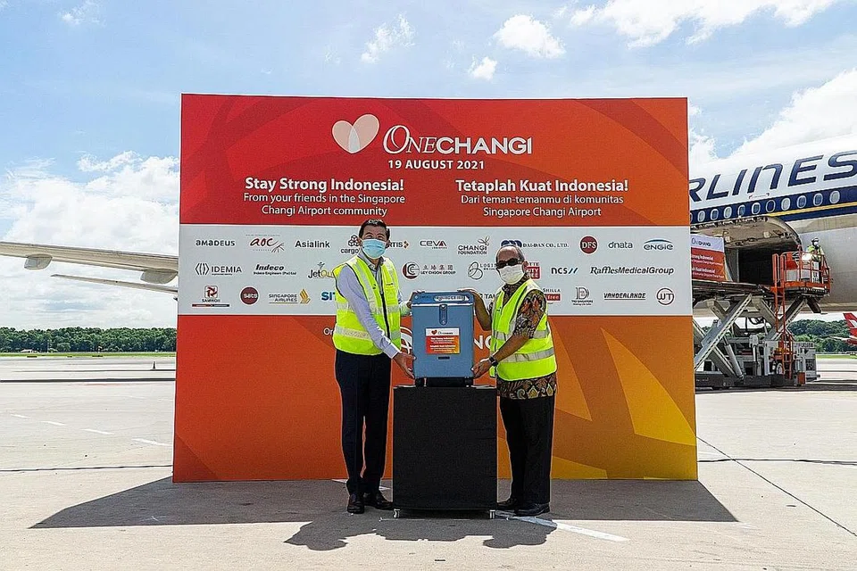 HULUR BANTUAN: Encik Lee (kiri) meyerahkan penumpu oksigen kepada Duta Besar Indonesia ke Singapura, Encik Suryo Pratomo dalam usaha memerangi wabak Covid-19 di negara itu. - Foto CHANGI AIRPORT GROUP