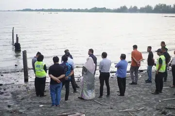Pihak berkuasa Malaysia memeriksa kawasan yang terjejas akibat tumpahan minyak di Pengerang, Johor, pada 19 Jun.