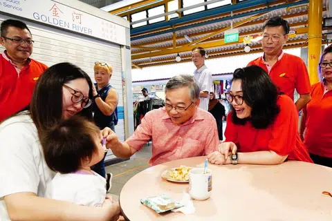 Timbalan Perdana Menteri (DPM) Encik Gan Kim Yong (empat dari kiri) dan Anggota Parlimen (AP) GRC East Coast, Cik Hazlina Abdul Halim (tiga dari kanan) beramah-mesra dengan penduduk di Pusat Penjaja Fengshan di Blok 85 Bedok North Street 4 pada 26 April.