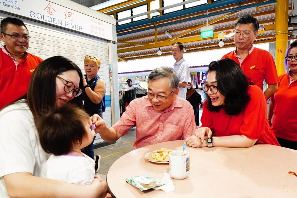 Timbalan Perdana Menteri (DPM) Encik Gan Kim Yong (empat dari kiri) dan Anggota Parlimen (AP) GRC East Coast, Cik Hazlina Abdul Halim (tiga dari kanan) beramah-mesra dengan penduduk di Pusat Penjaja Fengshan di Blok 85 Bedok North Street 4 pada 26 April.