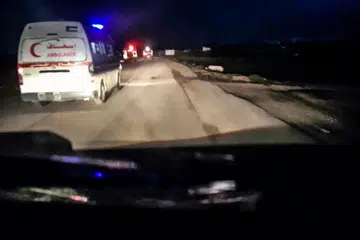 Video yang dipercayai dirakam dari dalam sebuah kenderaan bergerak, memaparkan sebuah trak bomba merah dan ambulans bergerak pada malam hari, dengan bunyi latar tembakan senjata berterusan.