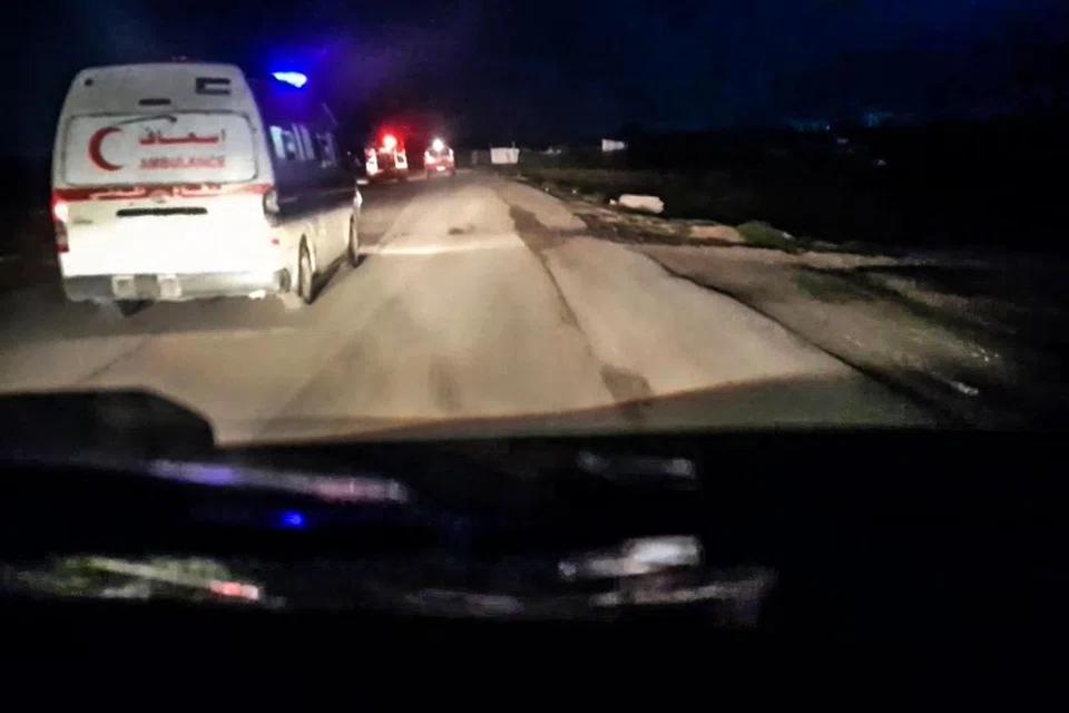Video yang dipercayai dirakam dari dalam sebuah kenderaan bergerak, memaparkan sebuah trak bomba merah dan ambulans bergerak pada malam hari, dengan bunyi latar tembakan senjata berterusan.