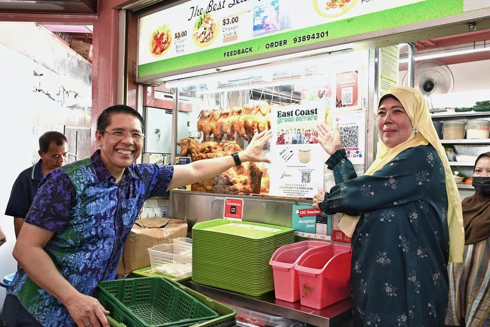 Menteri di Pejabat Perdana Menteri, Dr Mohamad Maliki Osman, yang juga penasihat kepada GRC East Coast, melancarkan inisiatif mampan baru di Pusat Makanan Bedok dan menampalkan poster untuk gerai yang terlibat. Bersamanya ialah Cik Roziah Adun, pemilik Nur Indah Kitchen dan juga wakil penjaja Pusat Makanan Bedok.