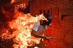 FOTO TERBAIK 2017: Imej ini diambil pada 3 Mei 2017 yang menggambarkan seorang penunjuk perasaan dari Venezuela berlari dalam keadaan seluruh tubuhnya terbakar semasa satu tunjuk perasaan terhadap Presiden Nicolas Maduro di ibu kota Caracas. Ia dirakam jurugambar AFP asal Venezuela Ronaldo Schemidt yang memenangi anugerah Foto Terbaik 2018 Foto Akhbar Sedunia (WPP) dan hadiah pertama bagi kategori 'Spot News Singles'. Acara penyampaian anugerah itu telah diadakan di Amsterdam, Belanda, pada 12 April 2018. Pengerusi panel juri Magdalena Herrera, yang juga pengarah fotografi Geo France, ketika mengulas pemilihan gambar ini sebagai pemenang, berkata: "Ia satu rakaman yang klasik, bertenaga dan dinamik. Warna, pergerakan, ia telah diambil dengan baik dan ia mempunyai tenaga tersendiri. Saya terus terasa terkesan." - Foto AFP