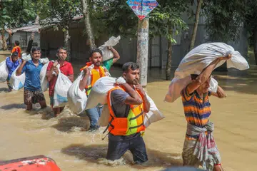 Relawan membawa bekalan bantuan di kawasan yang terjejas akibat banjir di Burichong, di Comilla, Bangladesh, pada 26 Ogos 2024.