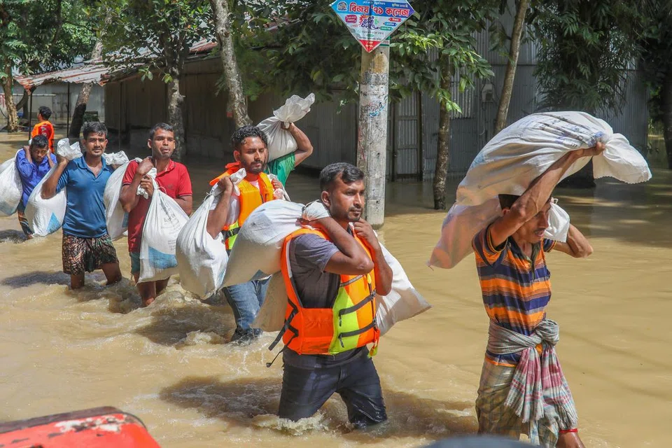Relawan membawa bekalan bantuan di kawasan yang terjejas akibat banjir di Burichong, di Comilla, Bangladesh, pada 26 Ogos 2024.