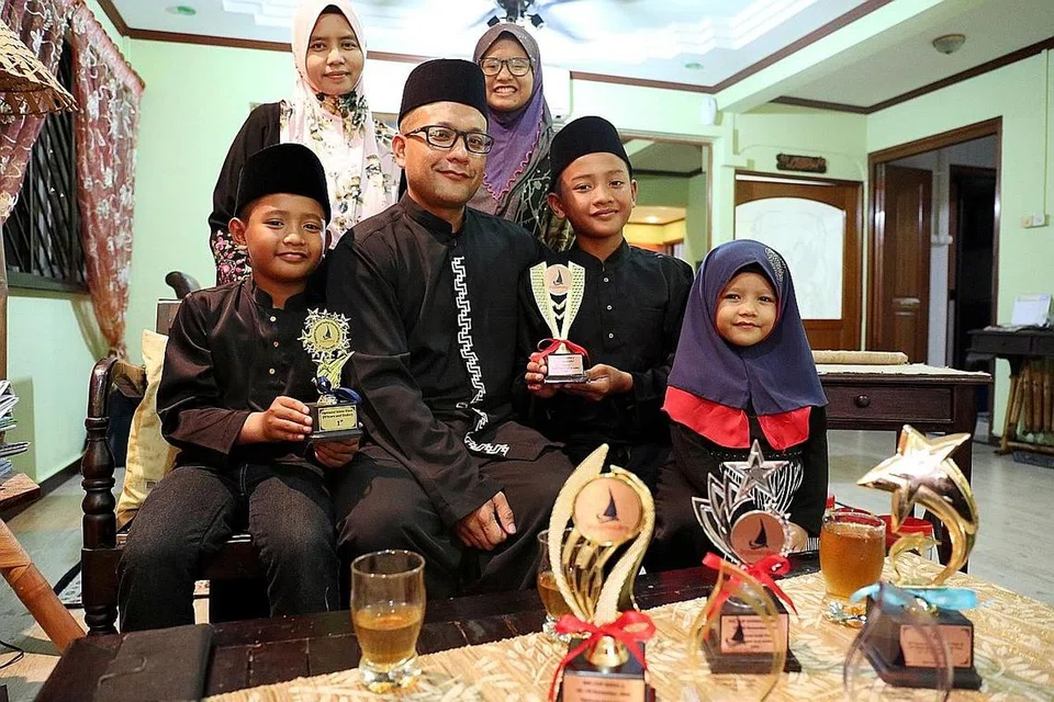 MELAYARI BAHTERA KELUARGA: Seperti kanak-kanak lain, Razin (duduk, kiri) dan Raihan ghairah menyambut Aidilfitri bersama ayah dan ibu mereka, Encik Airudin dan Cik Farida Taib (berdiri kiri), serta adik-beradik mereka, Siti Raudhah (berdiri) dan Siti Ra'idah. - Foto FAKHRURADZI ISMAIL