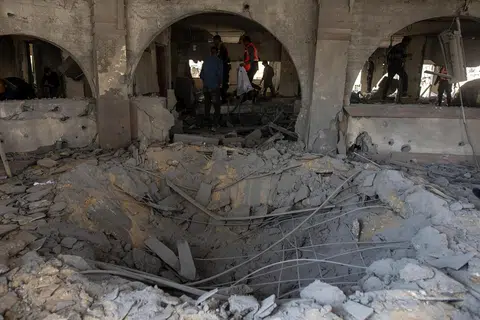 Penduduk Palestin memeriksa kesan kemusnahan akibat serangan udara Israel yang menyasarkan ibu pejabat Kementerian Dalam Negeri yang dikendalikan Hamas di Khan Younis, selatan Gaza, pada 2 Januari. 
