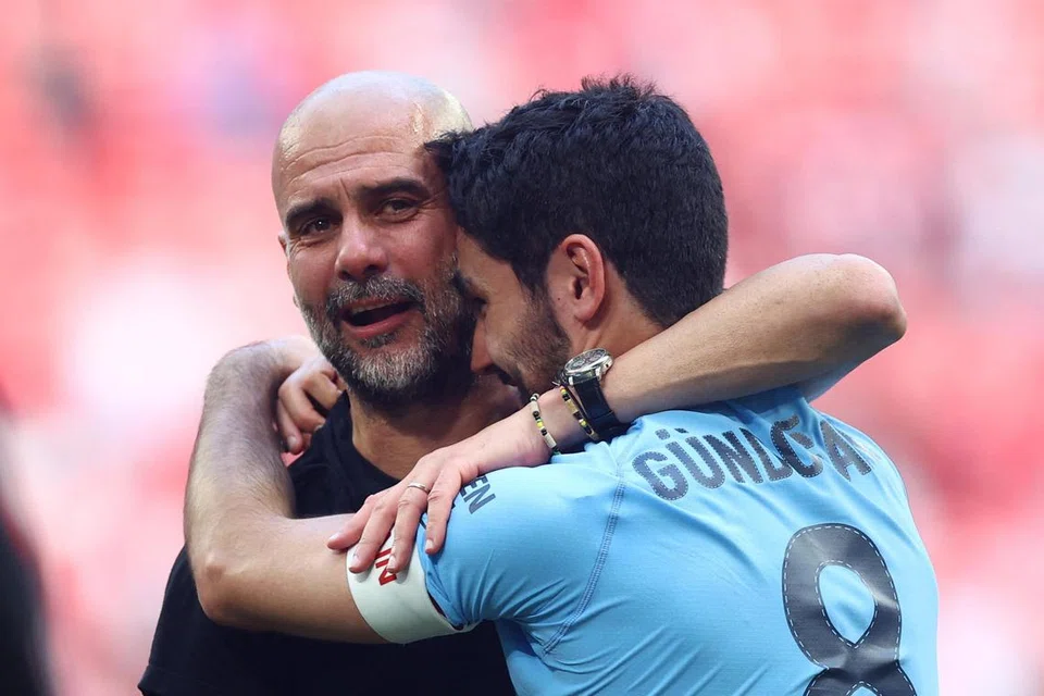 TERHARU DENGAN KEJAYAAN: Pengurus 
Manchester City, Pep Guardiola (kiri) memeluk kapten pasukannya, Ilkay Gundogan, yang menjaringkan dua gol bagi membuka peluang kepada kelab juara Liga Perdana  England itu untuk memenangi tiga kejuaraan musim ini. City akan beraksi dalam final Liga Juara-Juara Uefa menentang Inter Milan pada 10 Jun. 