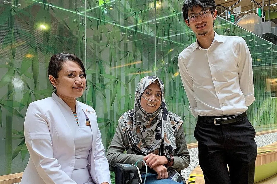 TERIMA BIMBINGAN RAWATAN TERAPI IV: Cik Haslina Wannor (tengah) mengendalikan rawatan terapi IV dengan bimbingan dan penjagaan pakar jururawat dari unit penjagaan pengkhususan kejururawatan NHCS, Cik Aidila Ismail (kiri) dan Profesor Madya Jonathan Yap (kanan), kededuanya dari pasukan Tekanan Darah Tinggi Pulmonari Pusat Jantung Nasional Singapura (NHCS). Gambar diambil sebelum tempoh pemutus litar. - Foto PUSAT JANTUNG NASIONAL SINGAPURA (NHCS)