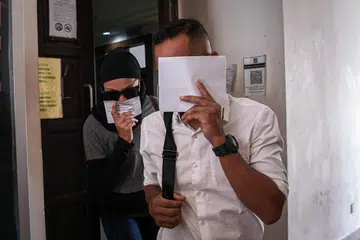 Seorang suri rumah (kiri) menukar pengakuan kepada tidak bersalah di Mahkamah Sesyen di sini atas pertuduhan menganiaya anak lelakinya dengan memberi minum susu bercampur air yang mengandungi methamphetamine. Suaminya juga mengekalkan pengakuan tidak bersalah atas pertuduhan sama.