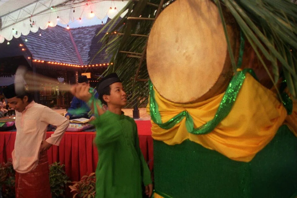 Seorang lelaki memukul beduk bagi menandakan waktu Maghrib dan waktu berbuka telah tiba, di Kampung Melayu Geylang Serai pada 1996. Kampung Melayu itu kini telah digantikan dengan bangunan Wisma Geylang Serai. 