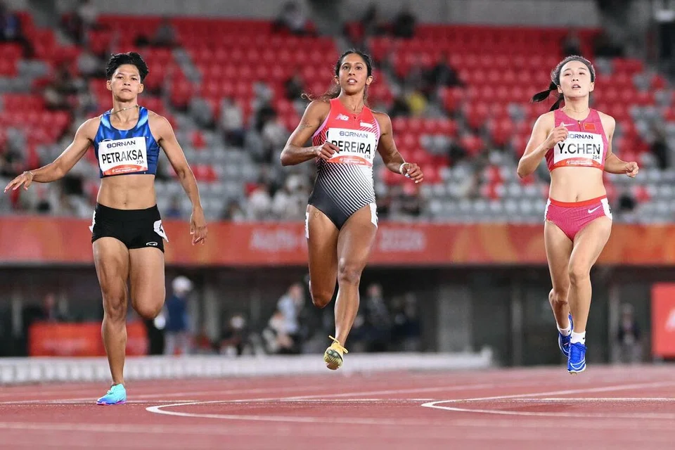 Atlet pecut Singapura, Shanti Pereira (tengah), mencatatkan masa 11.43 saat dalam Saringan 1 untuk berada 0.02 saat di belakang wakil China, Chen Yujie (kanan) dalam acara 100 meter wanita Sukan Asia.
