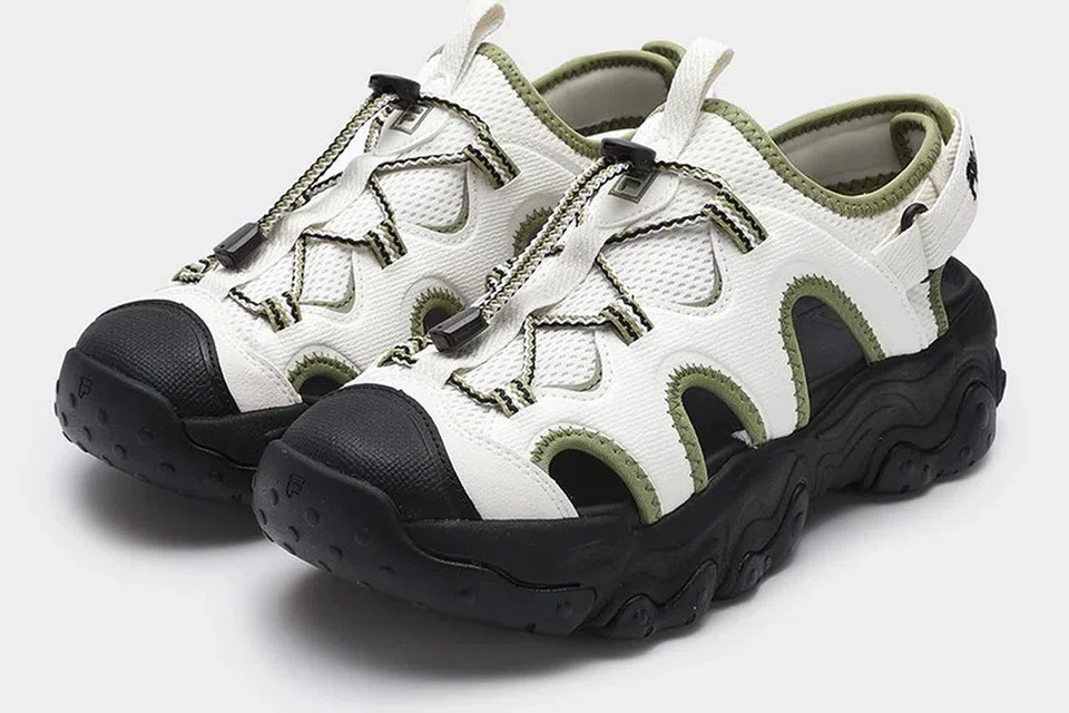 Sandal ‘FILA Core Fluid 5 Fashion Originale’ ini menawarkan keselesaan dan gaya dengan tali boleh dilaras serta gabungan warna hitam, putih, dan hijau. Dijual pada harga $102.40, sandal ini sesuai untuk kegunaan harian atau kegiatan santai.