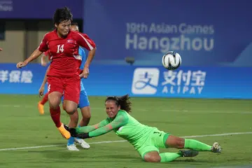 TEMUI SASARAN: Pemain Korea Utara Hong Songok menanduk gol pertama pasukan menentang Singapura dalam perlawaan pembukaan Kumpulan C Sukan Asia Hangzou di Stadium Pusat Sukan Wenzhou pada Ahad.