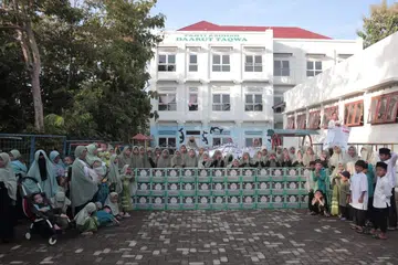 Anak yatim Daarut Taqwa di Yogyakarta, Indonesia, bergambar di hadapan bangunan tempat tinggal mereka  yang di bawah naungan Attawasol Insaniy Singapura pada Hari Raya Aidilfitri tahun 2024. 