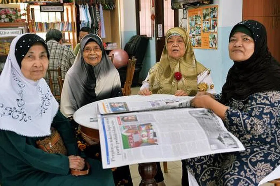 GEMAR BERINTERAKSI: Cik Tomirah (dua dari kiri) sering bertemu dengan kawan dan jiran sama ada untuk berbual atau melakukan kegiatan bersama seperti membaca akhbar, bermain congkak dan pelbagai kegiatan lain. - Foto KHALID BABA