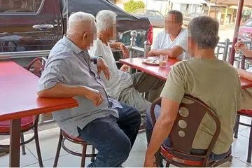 Gambar yang ‘menangkap’ Menteri Luar Malaysia, Datuk Seri Mohamad Hasan (kanan), merokok di sebuah premis makanan di Negeri Sembilan tular di media sosial dan beliau menerima kecaman awam.