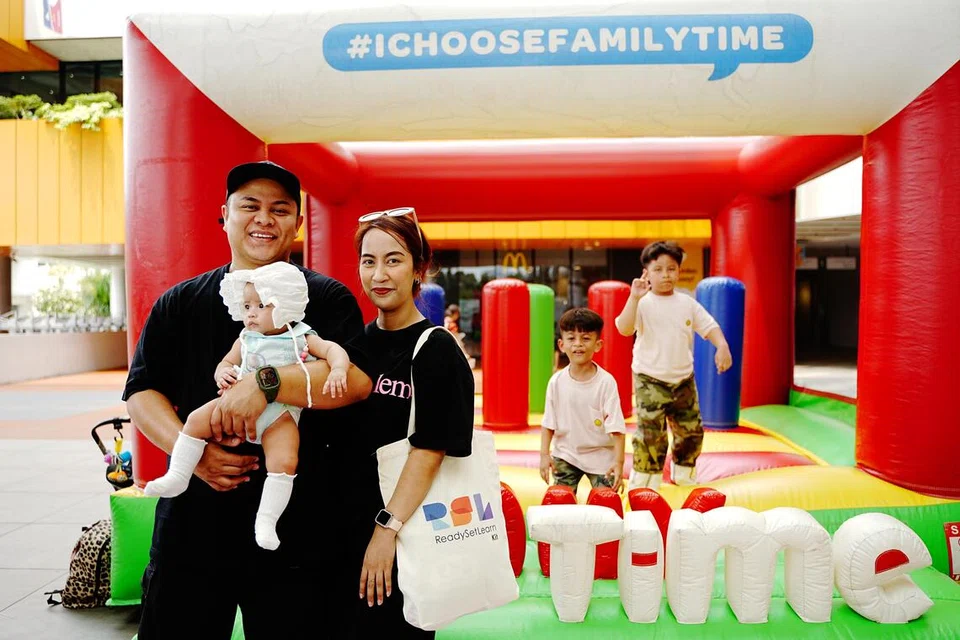 Cik Nuwaira Hanizam Aris dan Encik Mohammad Haikal Abdullah, bersama tiga anak mereka, (dari kiri) Niqkyla Hyfa Mohammad Haikal; Niqkyrel Hardy Mohammad Haikal; dan Niqkyle Hyder Mohammad Haikal; di kawasan permainan di acara penutup Raikan Ilmu 2026 di One Punggol pada 3 Oktober.