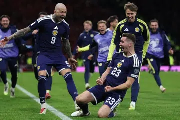 Kenny McLean (tengah) dari Scotland meraikan gol keempat pasukan itu bersama Lyndon Dykes (kiri), dalam perlawanan menentang Denmark pada 18 November.