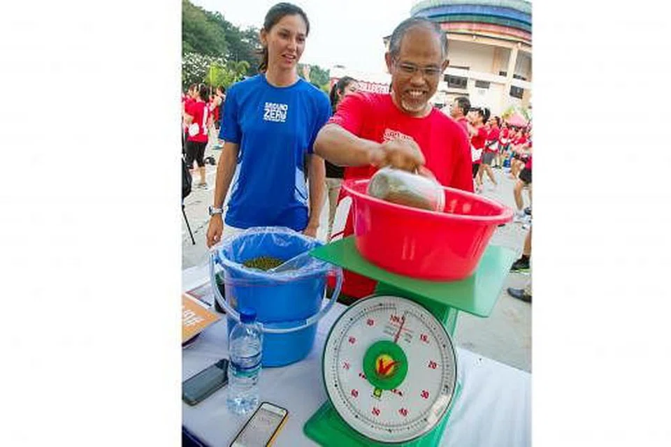 DEMI TINGKAT KESEDARAN: Encik Masagos turut mengambil bahagian dalalm kegiatan sampingan. Bersamanya ialah Pengarah Eksekutif Mercy Relief Cik Zhang Tingjun. 