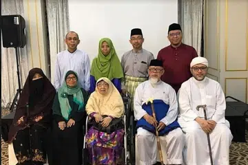 SEMUA BERJAYA: Allahyarhamha Ustazah Kalthom bersama suami Encik Hassan serta bersama anak-anak mereka: (duduk dari kiri) Cik Hasmidah, Ustazah Haslinda serta Ustaz Hasbi dan (berdiri dari kiri) Ustaz Dr Haniff, Cik Nurhasni, Dr Hafidz dan Ustaz Dr Hannan. - Foto ihsan USTAZ DR MOHAMMAD HANNAN HASSAN