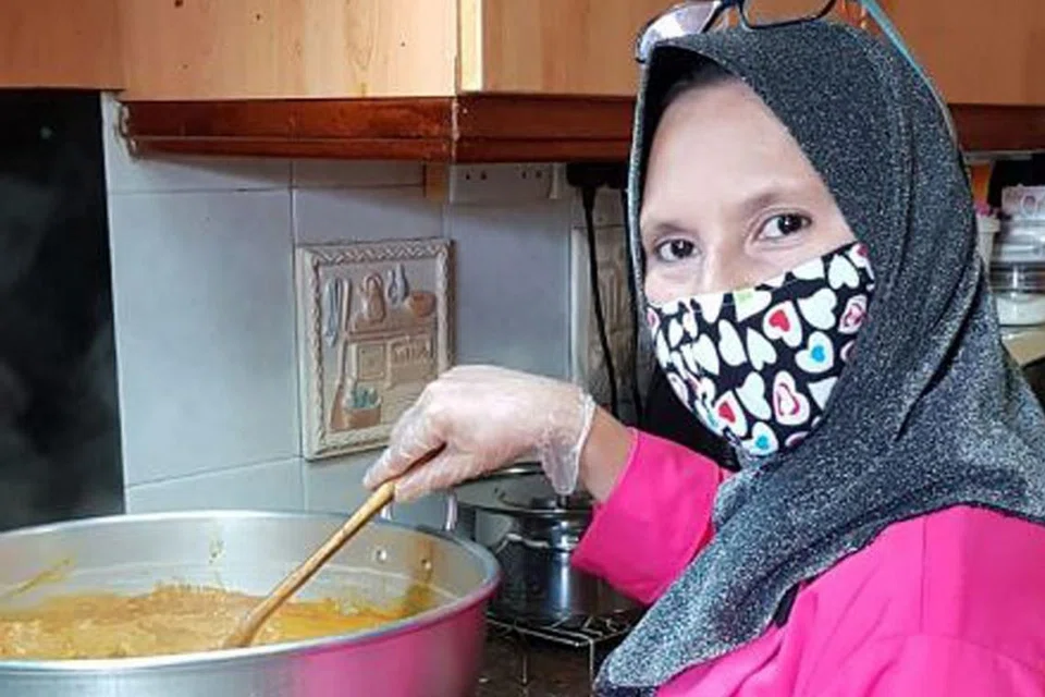 BERSYUKUR SAMBUNG OPERASI: Cik Harfa Abdul Karim, pemilik perniagaan di rumah, memasak kari ayam. Ia merupakan sebahagian menu iftar yang dijualnya kepada pelanggan. - Foto ihsan HARFA ABDUL KARIM
