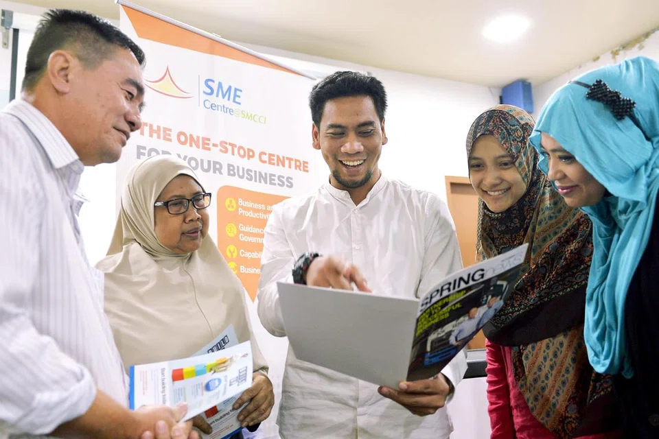 MEMPERKASA SME: Encik Hamdan (tengah) sedang berbincang dengan beberapa peniaga mengenai projek yang dikendalikan Pusat SME@DPPMS. 