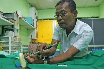 MANFAATKAN TEKNOLOGI: Encik Alluwie Manijan menggunakan alat moden yang dikatakan dapat menghasilkan potongan yang lebih kemas, cepat dan kurang sakit semasa menjalankan prosedur khatan. - Foto INIAZ RAHIM