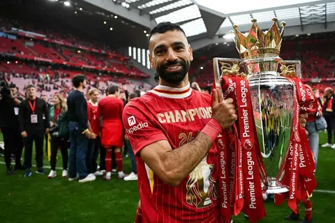 Penyerang Liverpool, Mohamed Salah, meraikan kejayaan bersama trofi EPL selepas perlawanan menentang Crystal Palace di Anfield, pada 25 Mei 2025. 