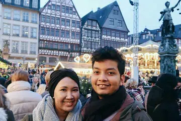 TERSELAMAT DEK KELETIHAN: Pasangan Cik Nurulhuda Syed Mahmood Albukhari dan suaminya, Encik Fairoz Leonard Wilfred D'Cruz, bersyukur tidak ke pasar Krismas Berlin kerana keletihan. Ini merupakan gambar mereka di pasar Krismas di Frankfurt beberapa hari sebelum kejadian rempuhan lori di Berlin. - Foto ihsan NURULHUDA SYED MAHMOOD ALBUKHARI